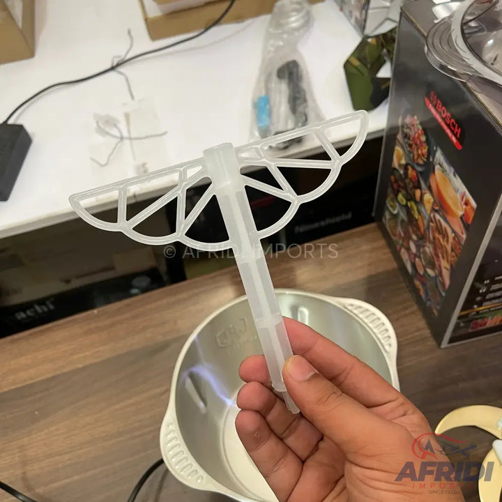 A clear plastic utensil with a fan-shaped, ribbed head and a handle for mixing.