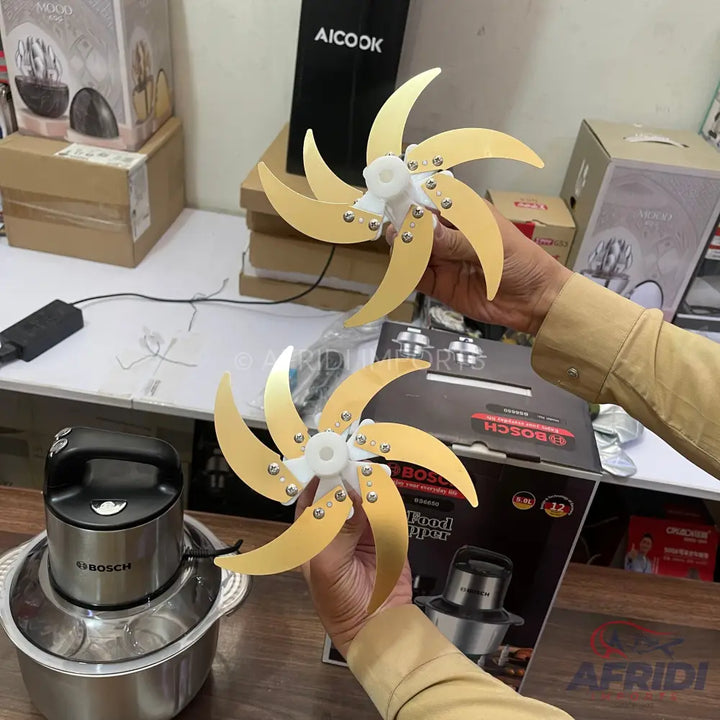 Two gold-colored, six-bladed chopper attachments for a food processor.