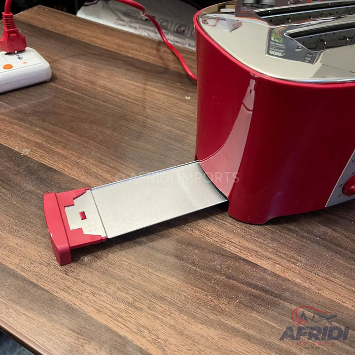 Red two-slice toaster with a pull-out crumb tray.