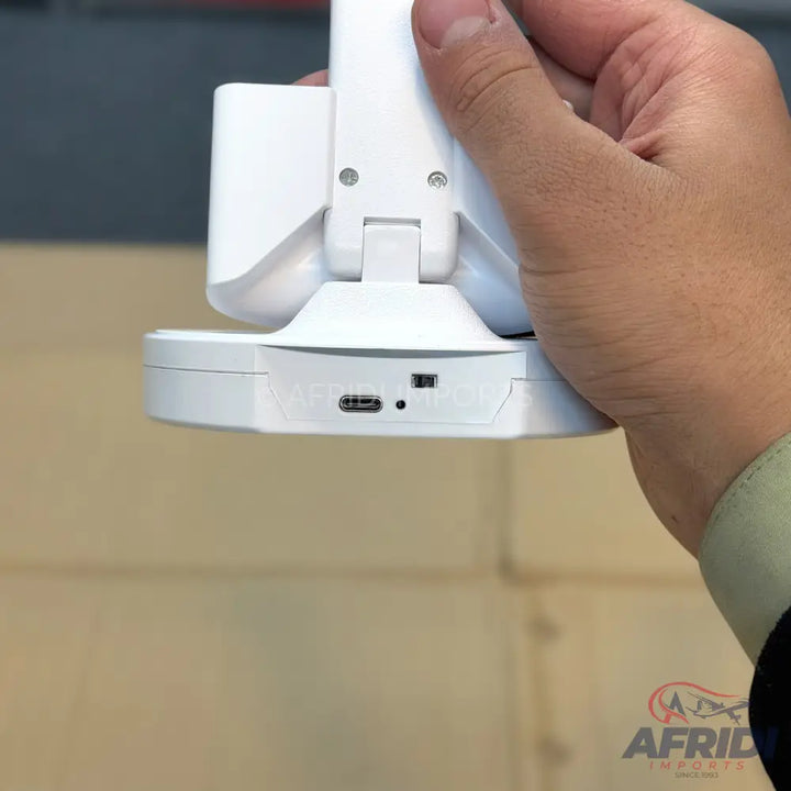 White portable electronic device with a USB-C port and a toggle switch, likely a webcam or camera.