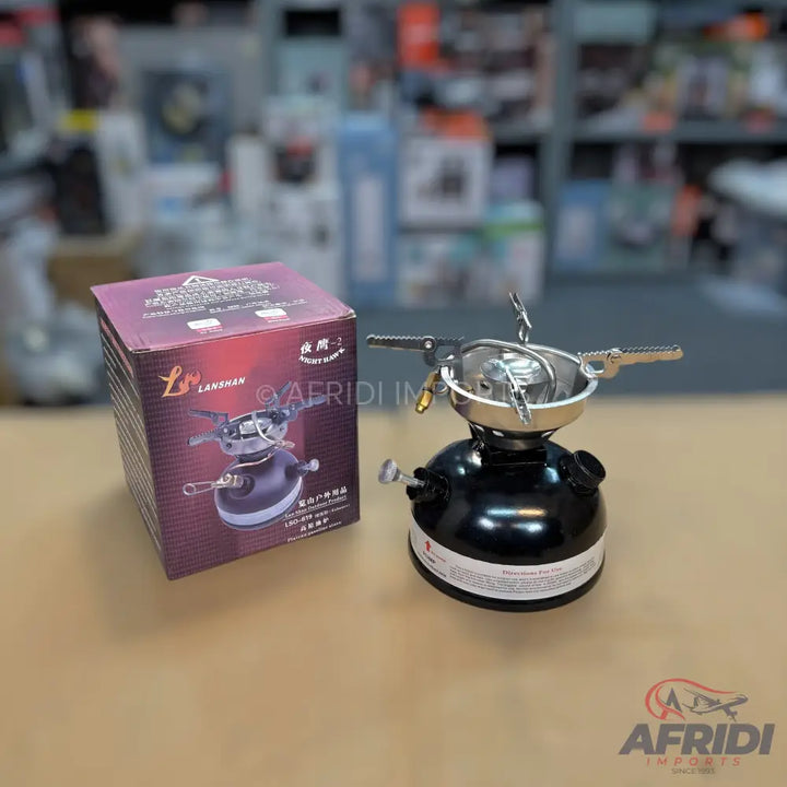 A black portable camping stove with a silver burner and pot support.