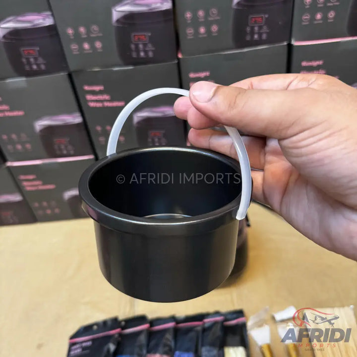 A black wax pot with a white handle.