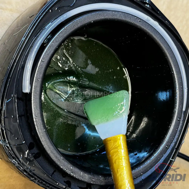 A tub of green gel wax with a silicone applicator brush.