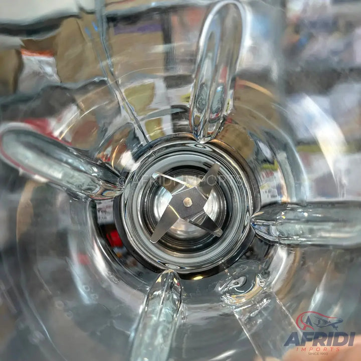 A clear glass blender jar with an internal four-blade assembly.