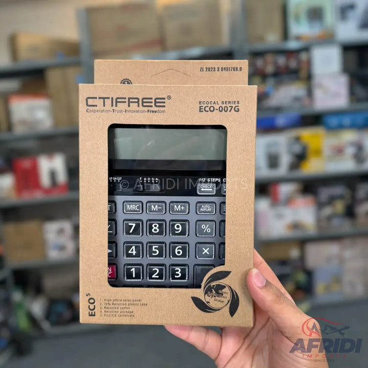 A black calculator with a large display, encased in eco-friendly cardboard packaging.