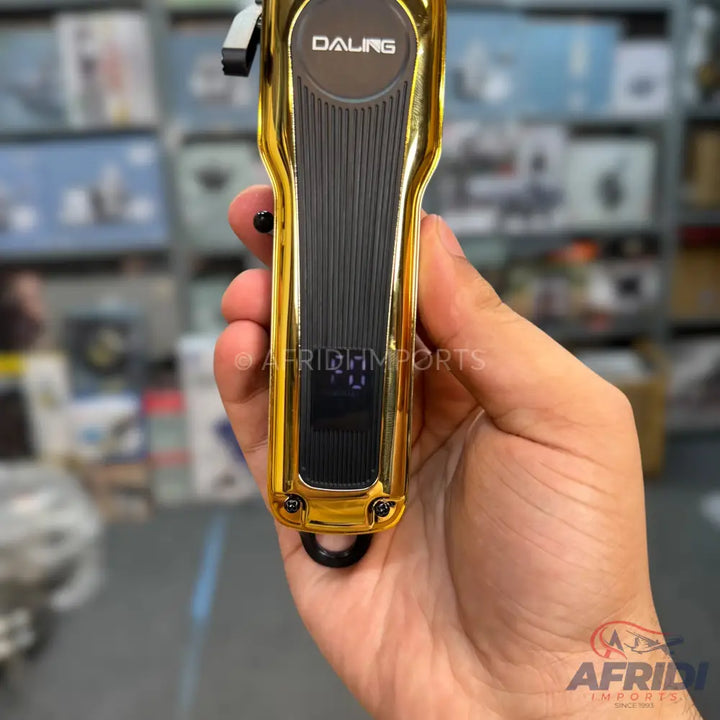 Gold and black electric hair clipper with a digital display.
