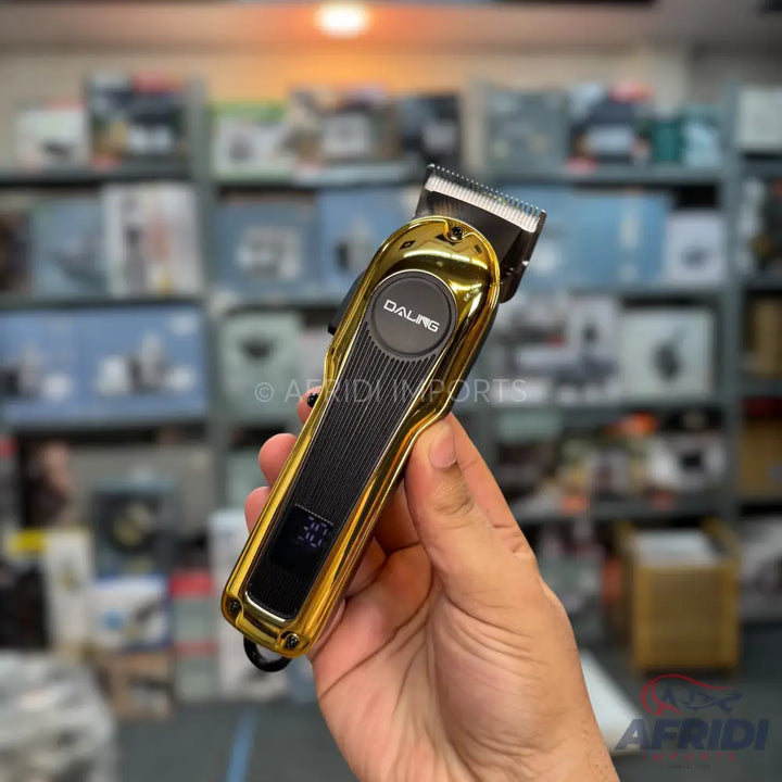 A gold and black electric hair clipper with a digital display.