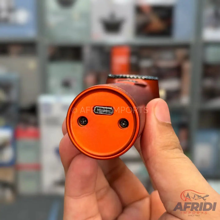An orange, cylindrical electronic device with a USB-C charging port and two small screws on its base.