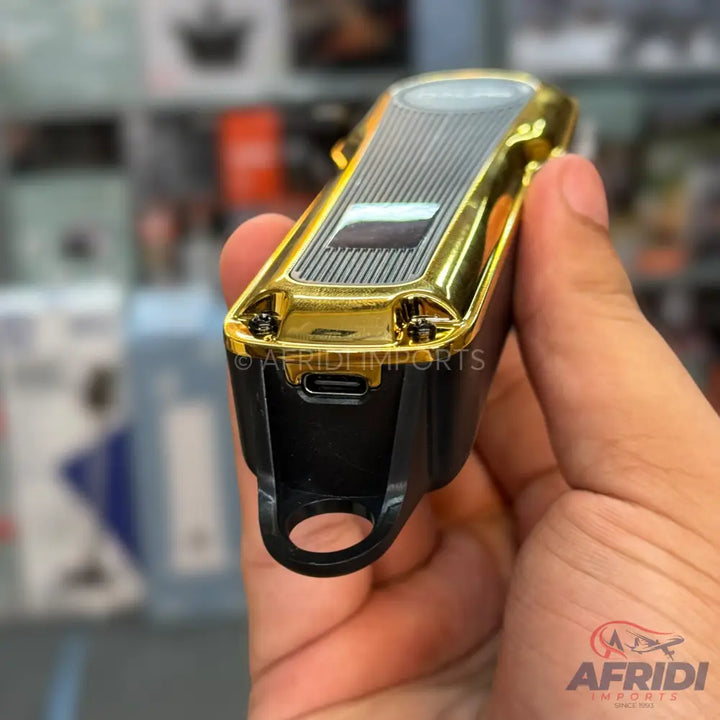 Gold and black electric hair trimmer with a USB-C charging port and a hanging loop.
