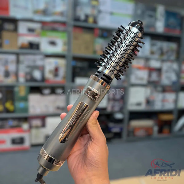 A silver and black hot air styling brush with a rotating barrel.