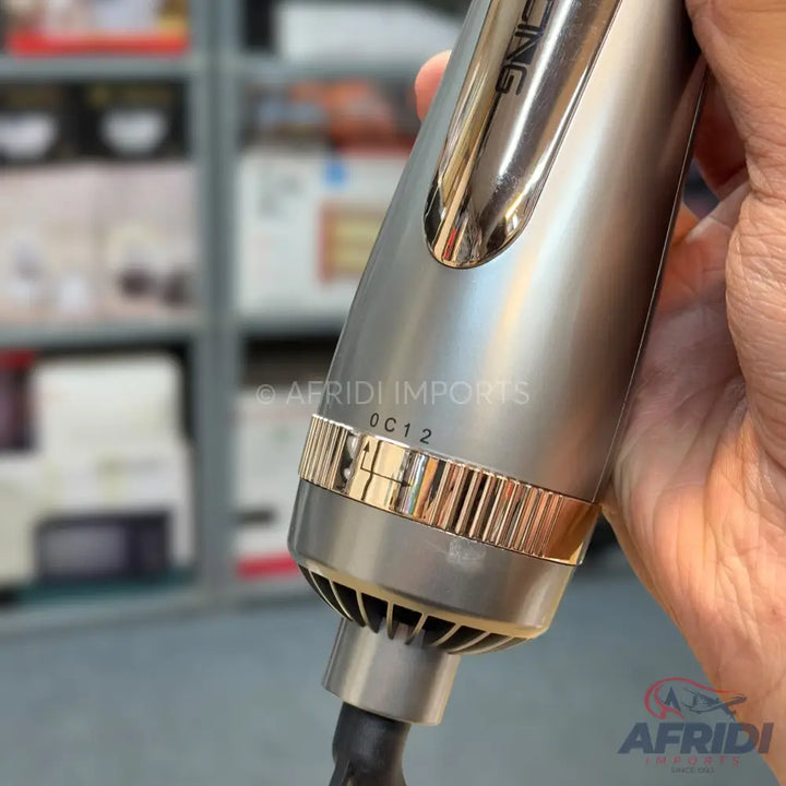 A gray and gold hair styling tool with a textured grip and visible air vents.