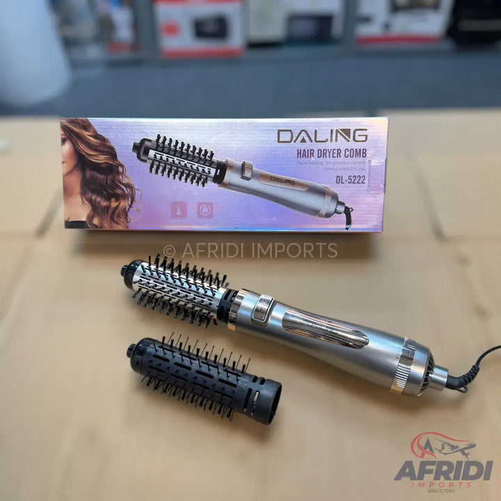 A silver hair dryer comb with two interchangeable brush heads, one with wider bristles and one with finer bristles.