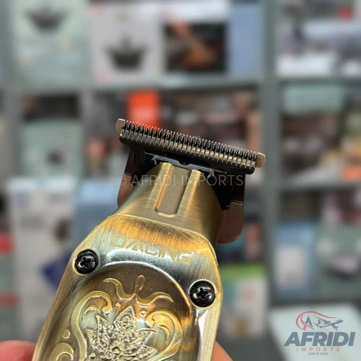 Close-up of a gold-colored, ornate hair trimmer with exposed blades.