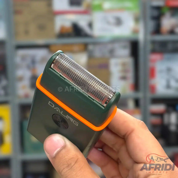 Dark green electric shaver with an orange band, featuring a dual-foil cutting head and a power button.