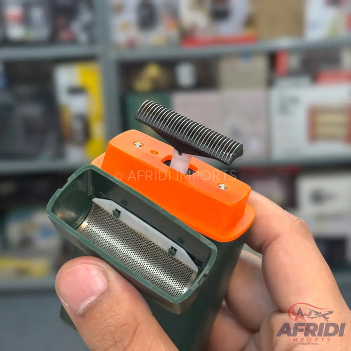 A dark green and orange electric shaver with a foil head and a pop-up trimmer.