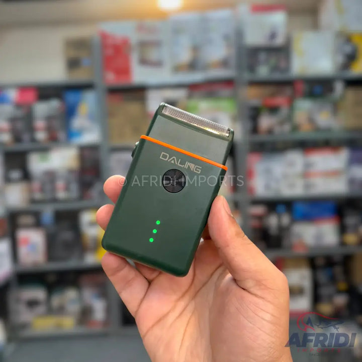 A dark green electric shaver with an orange stripe and three green indicator lights.