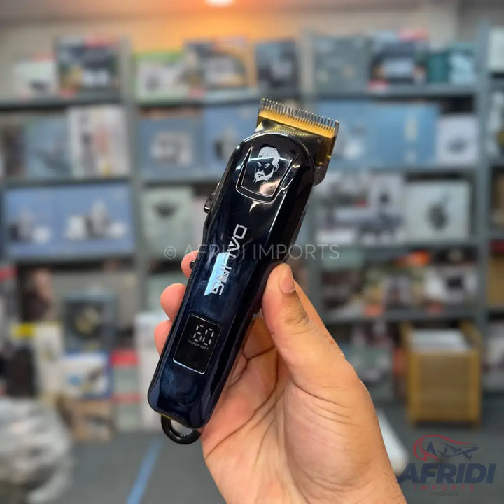 A dark blue hair clipper with a gold-colored blade and a digital display showing ’60’’.