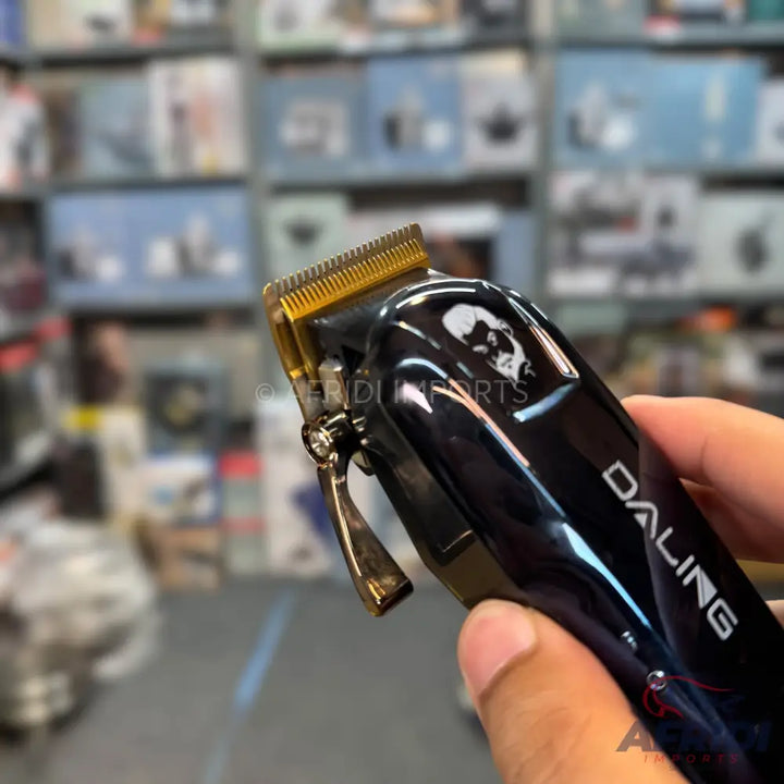 Black and gold electric hair clipper with a skull design.