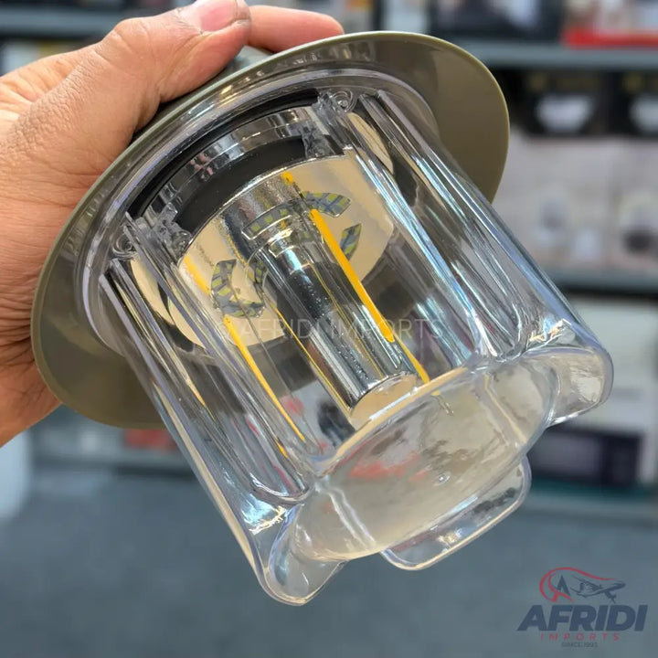 A clear, fluted plastic container with a metallic-looking, cylindrical center and a wide, flat rim.