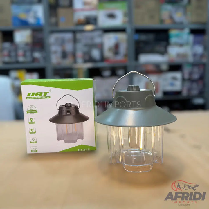 A portable, rechargeable LED lantern with a handle and a clear casing, packaged in a green and white box.