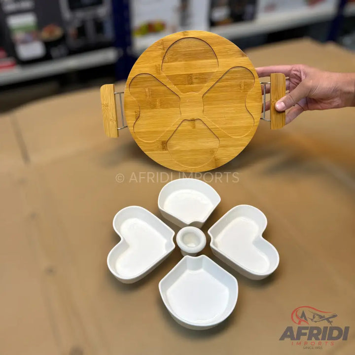 A wooden rotating serving platter with five heart-shaped ceramic bowls and a central dip bowl.