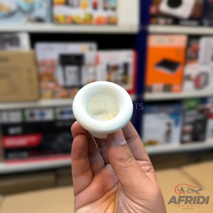 A small, white, bell-shaped ceramic or plastic object with a concave top.