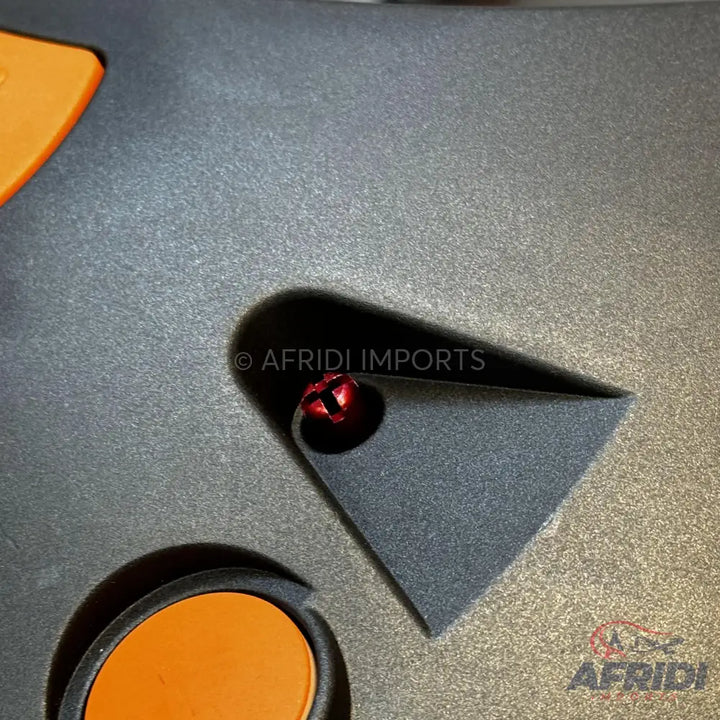 A dark gray, triangular, and curved object with a red bell-like element.