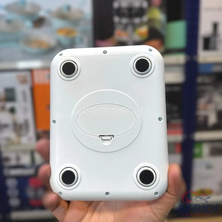 The underside of a white, rectangular digital kitchen scale with four circular feet and a central battery compartment.