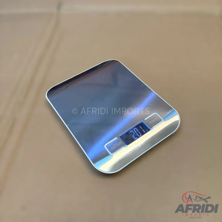 A digital kitchen scale with a silver, reflective surface and a blue backlit display showing ’20.1’’.