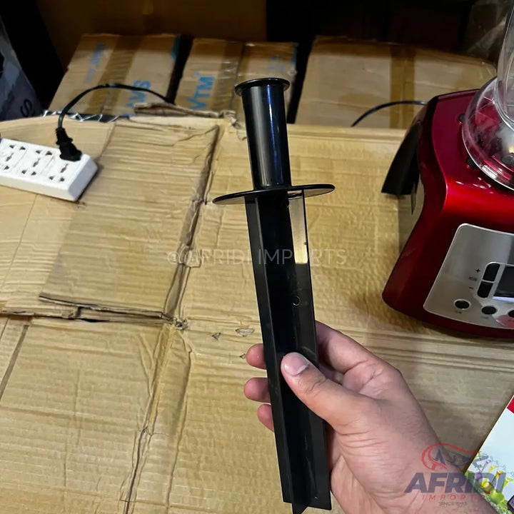Black plastic tamper for a blender.