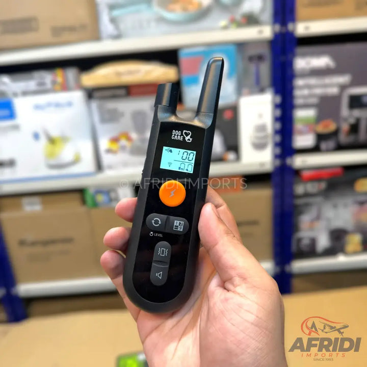 Black and orange dog training remote with a digital display.