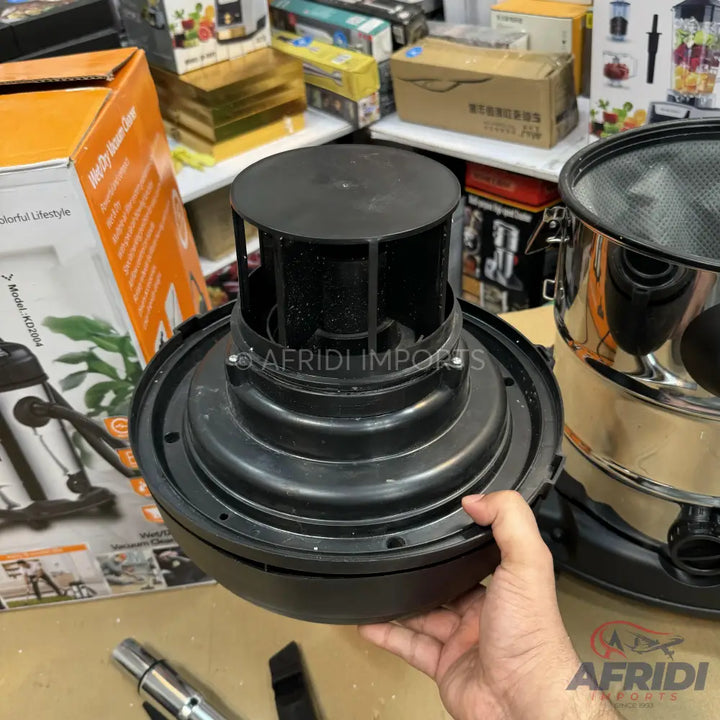 A black plastic vacuum cleaner motor housing with a circular top and open-slatted sides.
