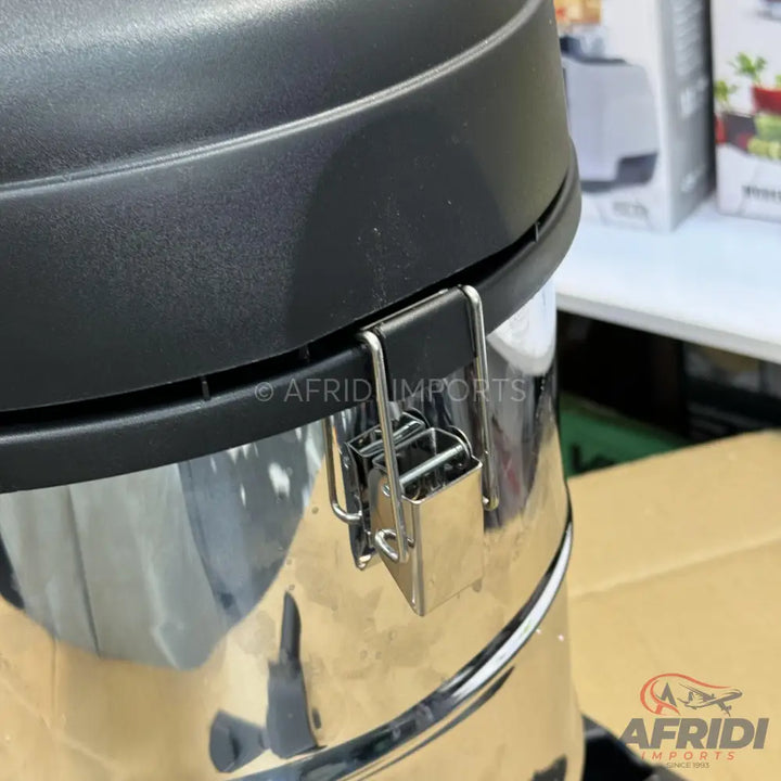 A shiny, metallic canister with a black lid and a metal latch, likely part of a vacuum cleaner or similar appliance.