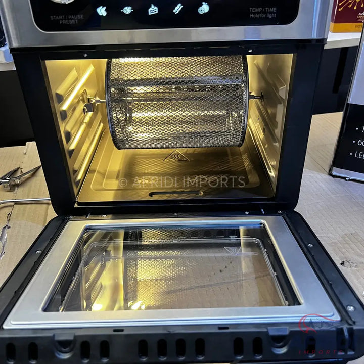 An open air fryer oven with a rotating mesh basket.