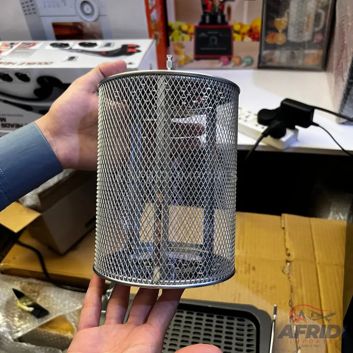 A cylindrical metal mesh air fryer basket with a rotisserie attachment.