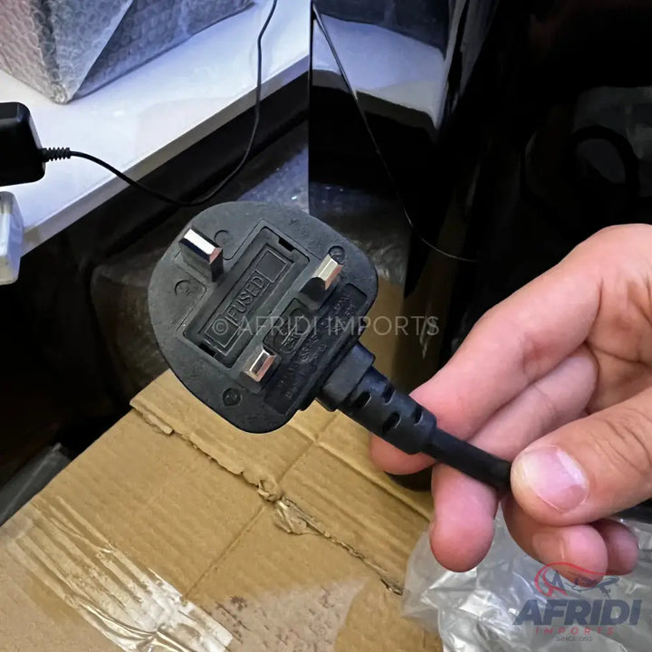 A black three-pin fused electrical plug with a cable.