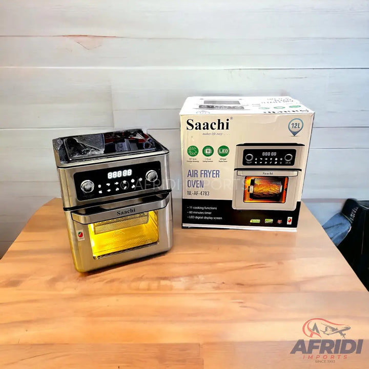 A silver Saachi air fryer oven with digital controls and a transparent door, packaged in its original box.