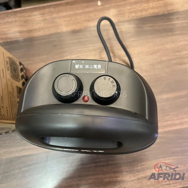 Compact black electric foot warmer with two control knobs and an indicator light.