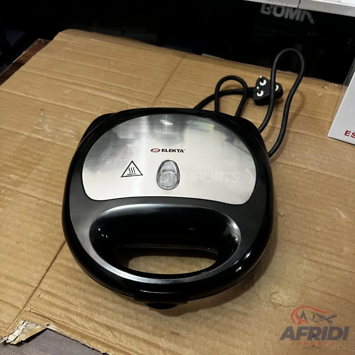 Black and silver sandwich maker with a power cord and three-prong plug.