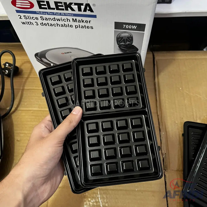 A 700W sandwich maker with three sets of detachable plates, including waffle plates.