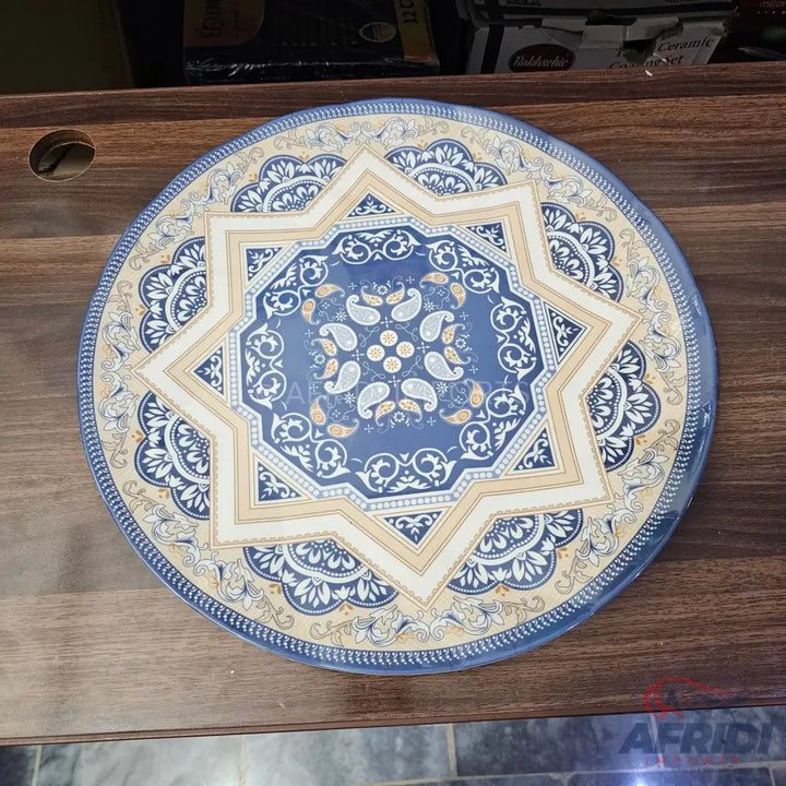 A round, blue and cream patterned dinner plate.