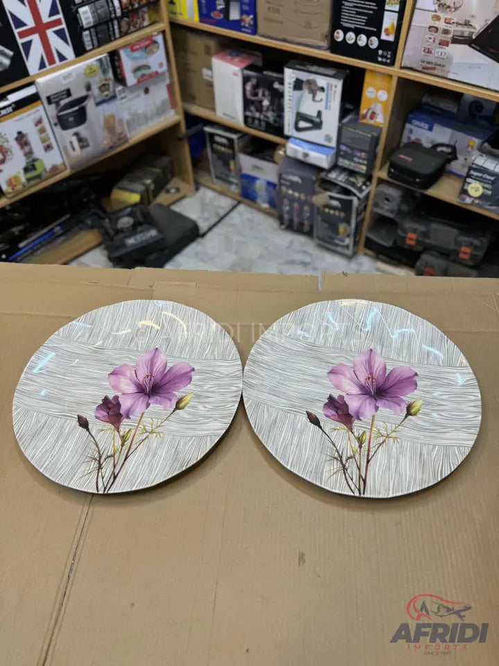 Two round decorative wall plates with purple flower designs.