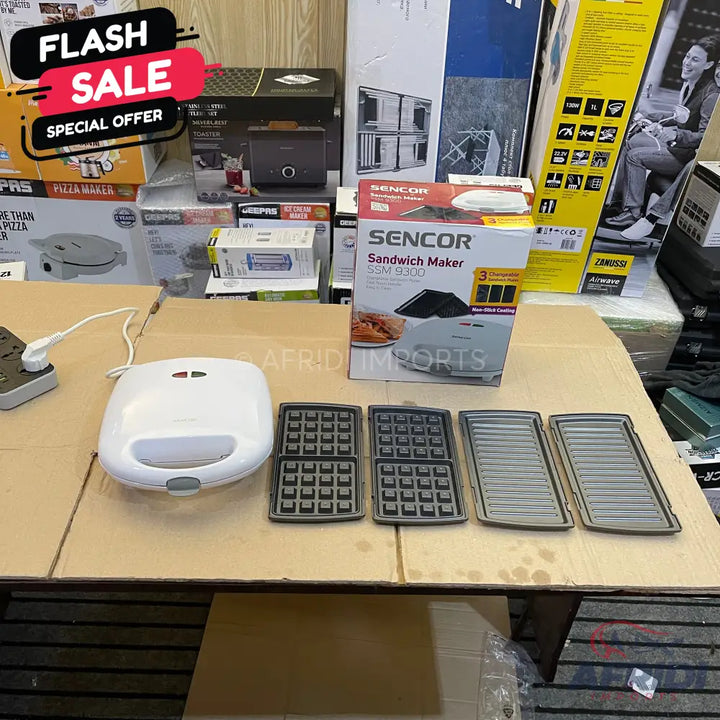 A white sandwich maker with interchangeable waffle and grill plates.