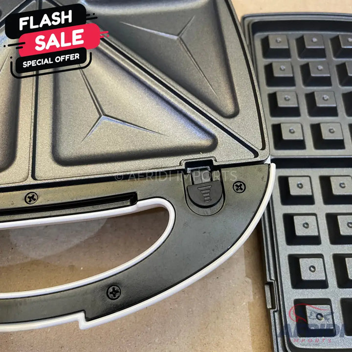 A black and white sandwich maker with interchangeable waffle plates.