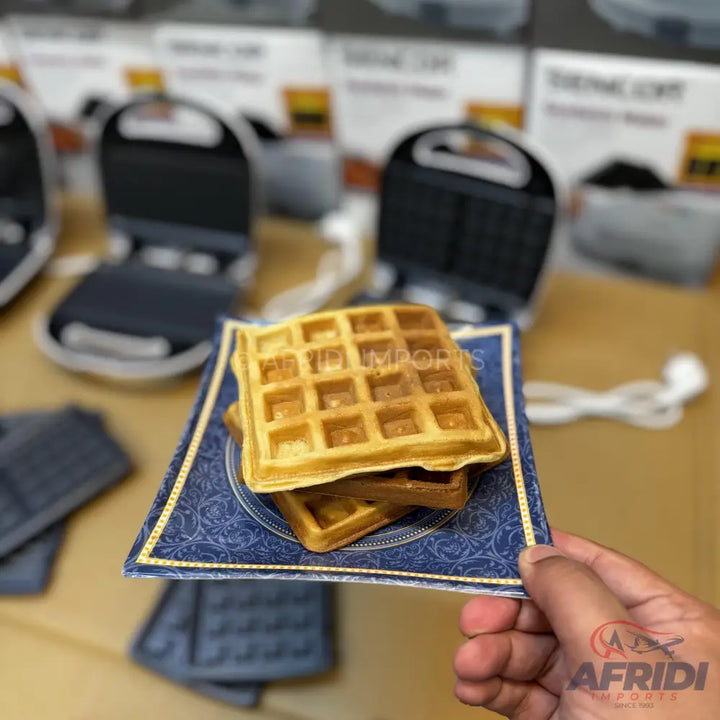 Golden brown, square-shaped waffles stacked on a decorative plate.