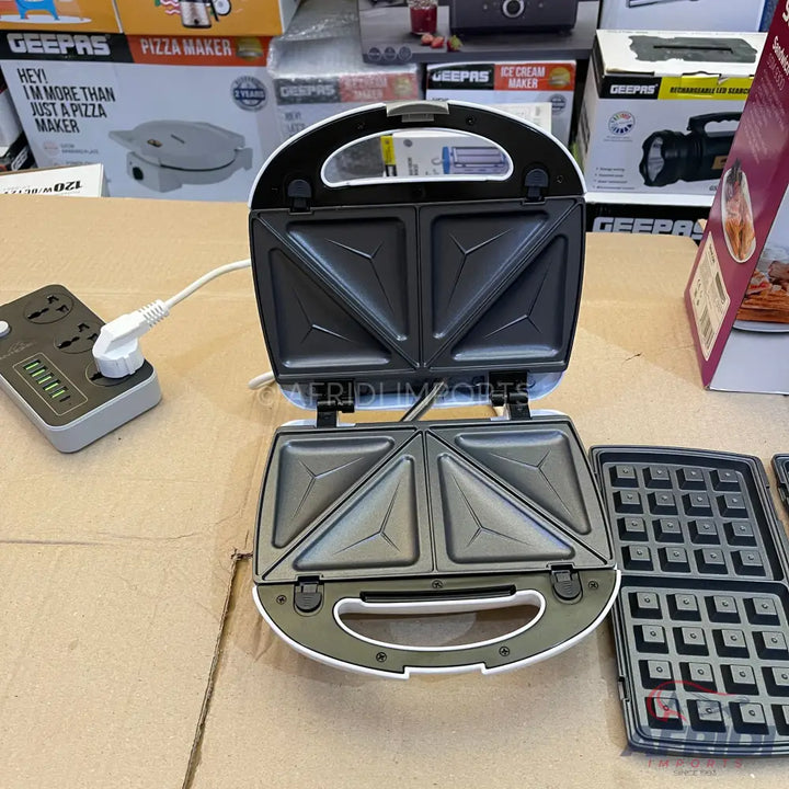 White and black open sandwich maker with interchangeable waffle plates.