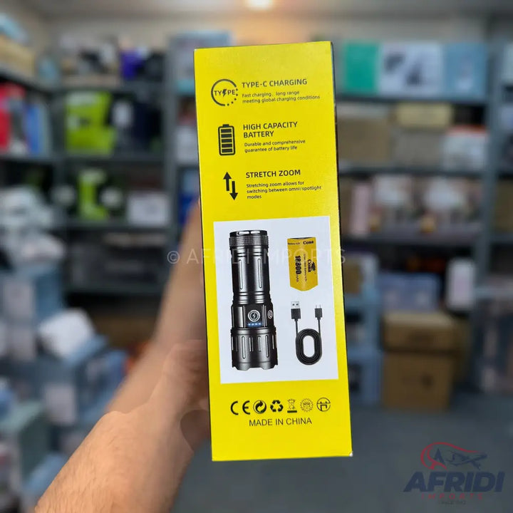 Yellow product packaging for a flashlight with features like Type-C charging, high-capacity battery, and stretch zoom.