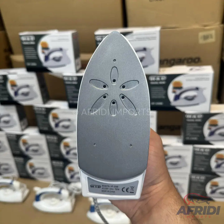 The soleplate of a gray and white travel iron with steam vents.