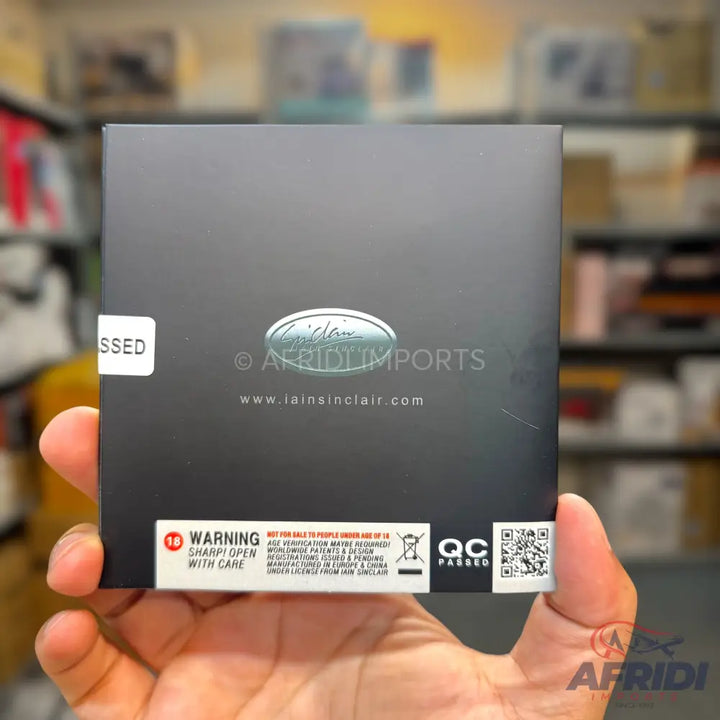 Black rectangular box with a ’New Product’ label, ’QC Passed’ stamp, and a warning about sharp contents.