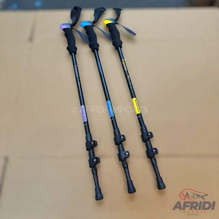 Three black trekking poles with colorful handles.